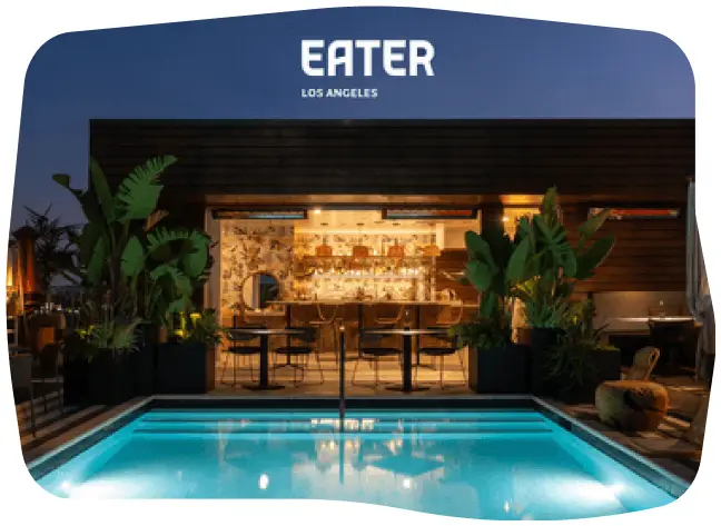 Stylish Videre outdoor pool area at night, with a well-lit bar in the background.