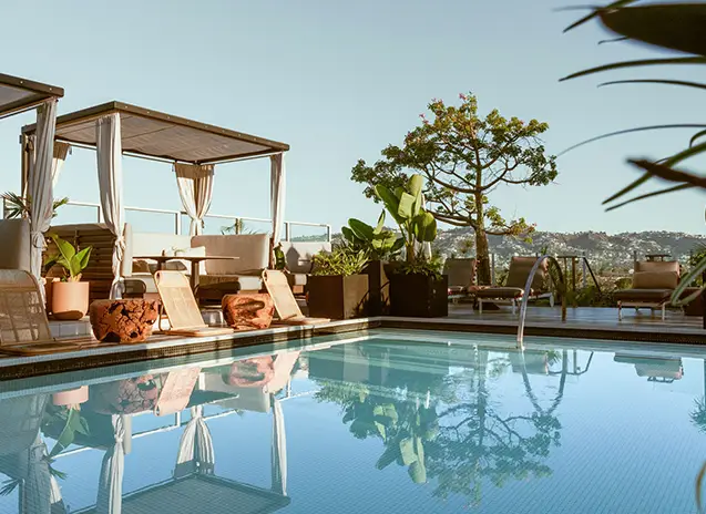 Swimming pool on a terrace with lounge chairs around, offering a panoramic view of the surrounding landscape.