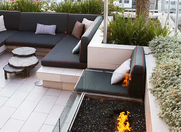 Outdoor relaxation area with comfortable seating, a coffee table, and a fire pit.